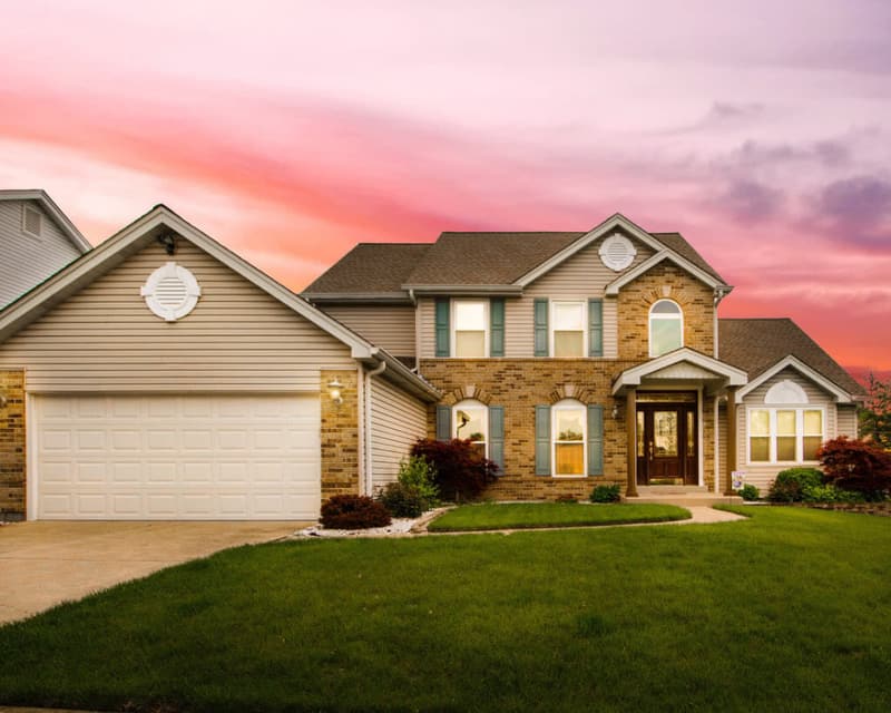 A brick and stone family home at sunset